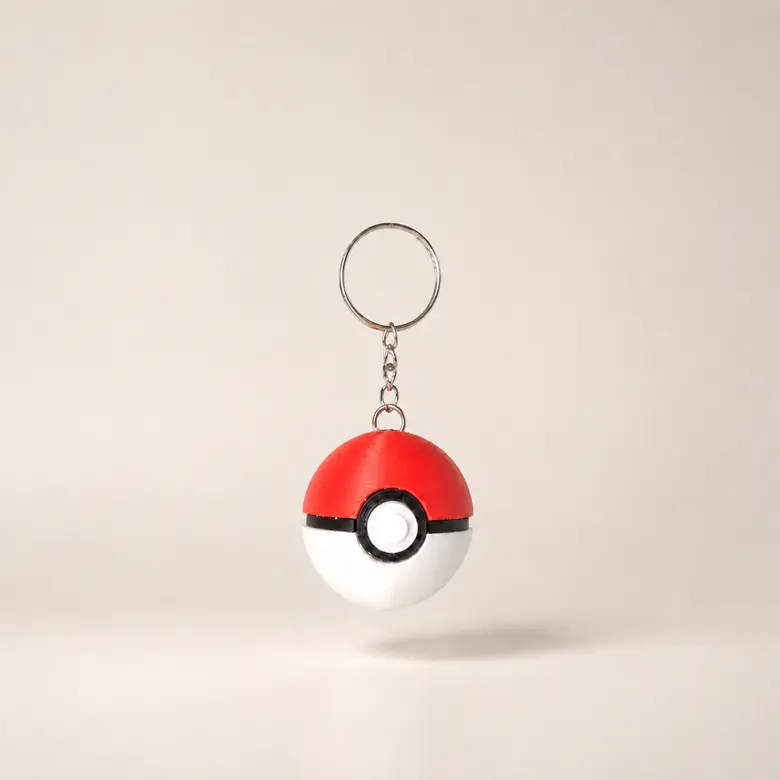 Llavero esférico rojo, blanco y negro inspirado en una Pokéball, centrado con cadena y argolla metálicas completas.